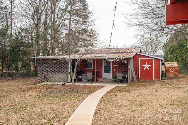 exterior space with a storage shed, a lawn, and a patio