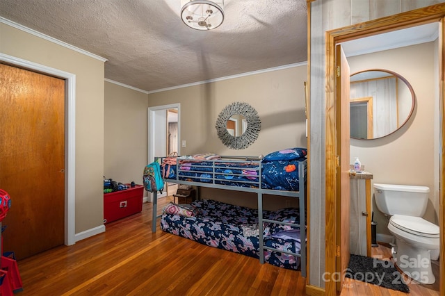 bedroom with crown molding, wood-type flooring, and a textured ceiling