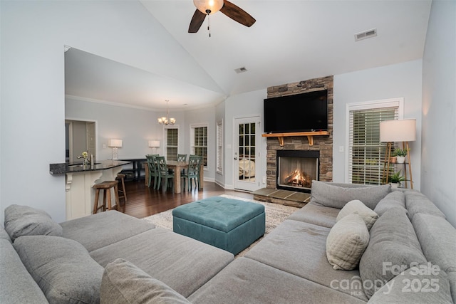 living room featuring high vaulted ceiling, ceiling fan with notable chandelier, a fireplace, and dark hardwood / wood-style flooring