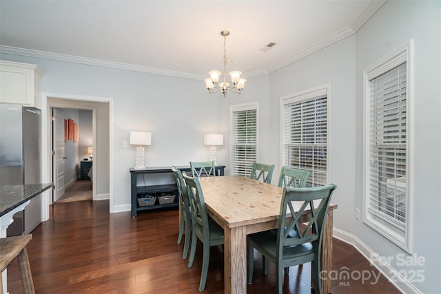 dining space featuring crown molding, dark hardwood / wood-style floors, and an inviting chandelier