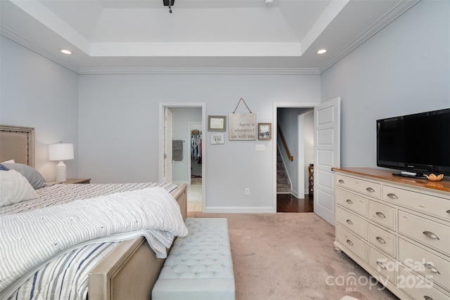 bedroom with carpet floors, ornamental molding, and a raised ceiling