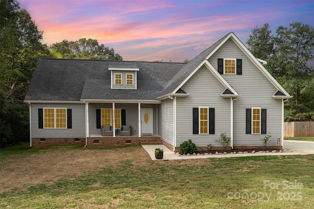 view of front of property featuring covered porch and a lawn