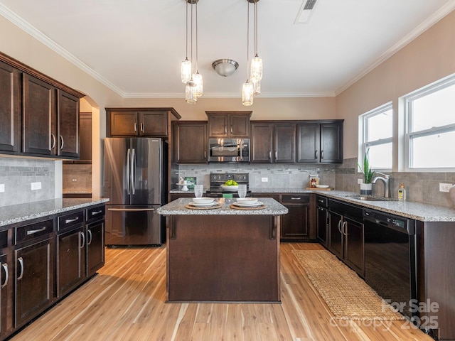 kitchen featuring pendant lighting, sink, a center island, dark brown cabinetry, and black appliances