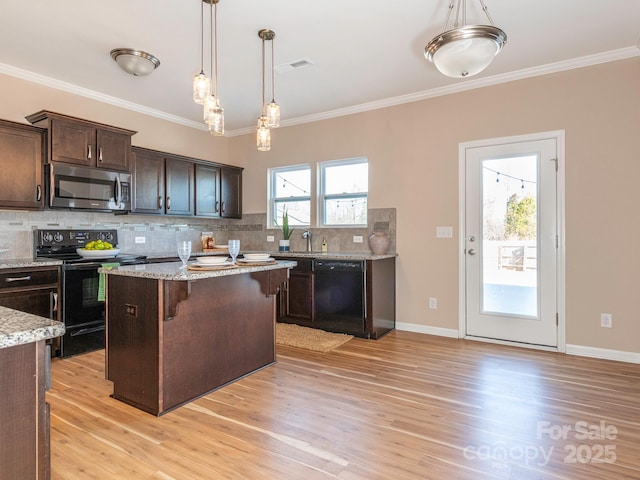 kitchen featuring a center island, light stone counters, dark brown cabinetry, black appliances, and light wood-type flooring