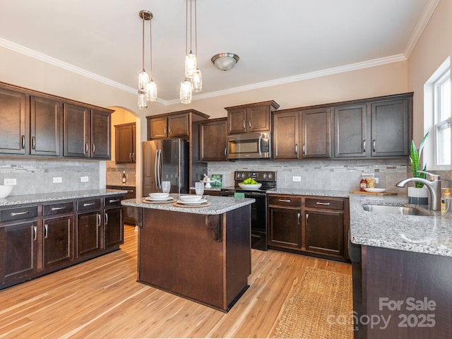 kitchen with pendant lighting, sink, dark brown cabinetry, light stone counters, and stainless steel appliances