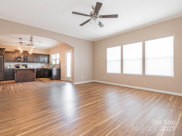 unfurnished living room with ceiling fan, ornamental molding, and light hardwood / wood-style floors