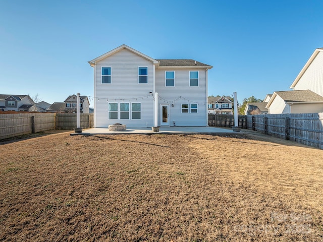 rear view of property featuring a yard and a patio area