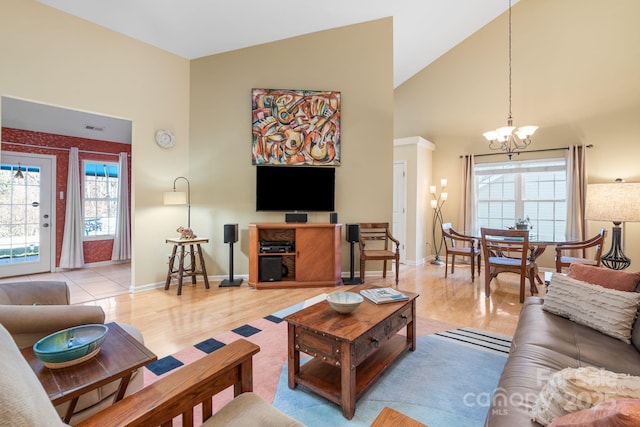 living room featuring visible vents, baseboards, a chandelier, wood finished floors, and high vaulted ceiling