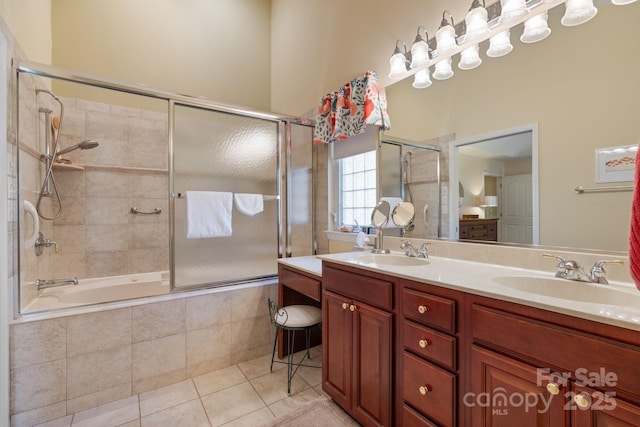 full bathroom featuring tile patterned floors, tiled shower / bath, double vanity, and a sink