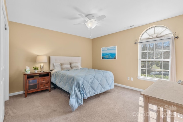 bedroom featuring ceiling fan, light colored carpet, visible vents, and baseboards