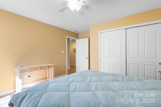 bedroom with carpet floors, baseboards, a closet, and ceiling fan