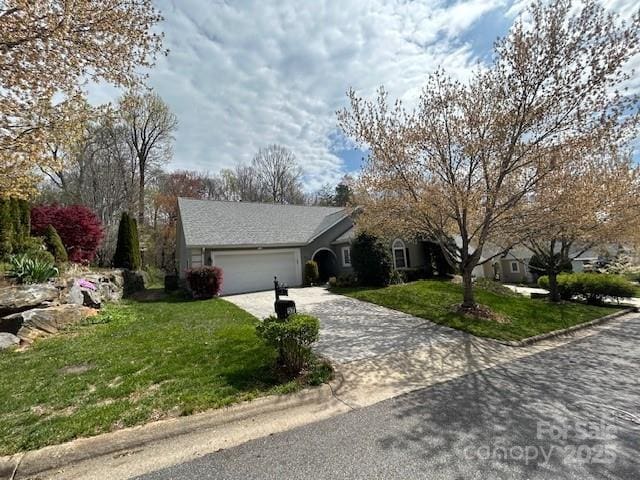 view of front facade with driveway, an attached garage, and a front lawn