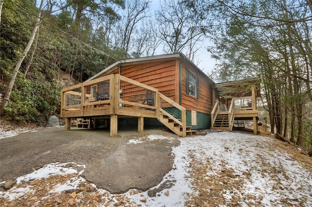 snow covered property with a deck