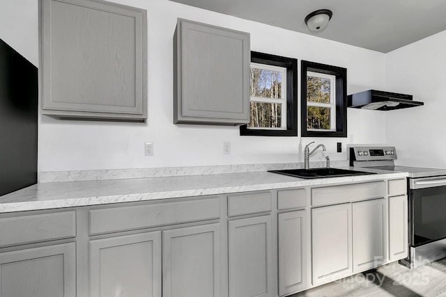 kitchen featuring sink, ventilation hood, stainless steel range with electric cooktop, and gray cabinets