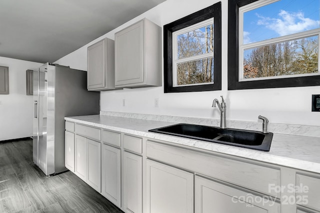 kitchen featuring stainless steel refrigerator, dark wood-type flooring, sink, and gray cabinetry