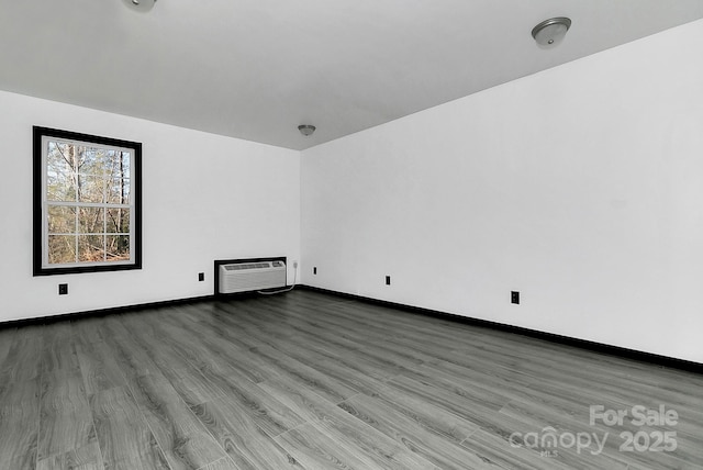 unfurnished living room with a wall mounted AC and hardwood / wood-style floors