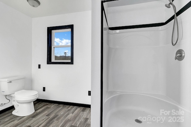 bathroom featuring walk in shower, hardwood / wood-style floors, and toilet