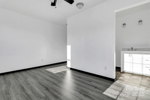 empty room with ceiling fan, dark hardwood / wood-style floors, and sink