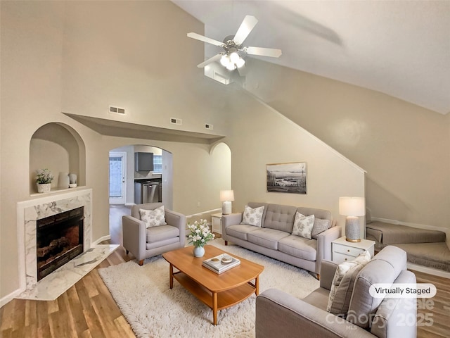 living room with lofted ceiling, hardwood / wood-style flooring, a fireplace, and ceiling fan