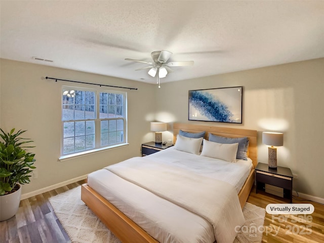 bedroom featuring hardwood / wood-style floors, a textured ceiling, and ceiling fan