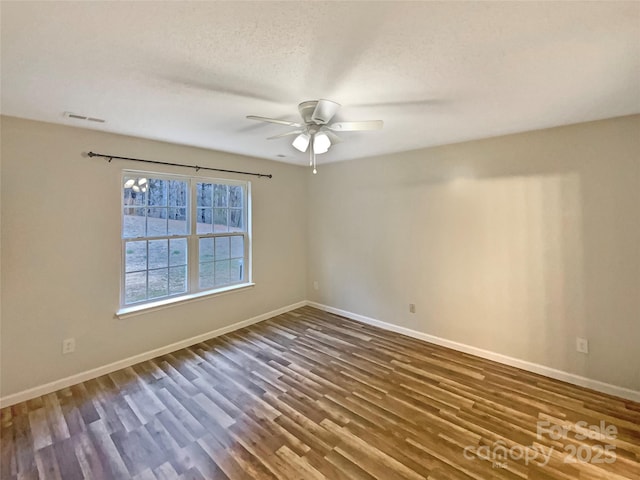 spare room featuring ceiling fan and dark hardwood / wood-style floors