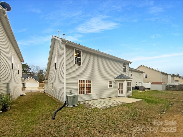 rear view of property with a storage shed, central AC unit, a patio area, and a lawn