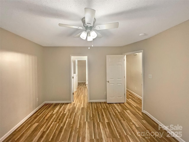 unfurnished bedroom featuring a textured ceiling, ceiling fan, and light hardwood / wood-style flooring