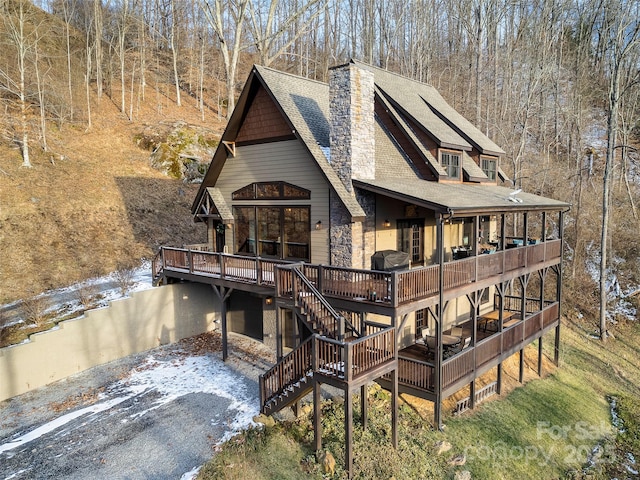 rear view of property featuring a wooden deck