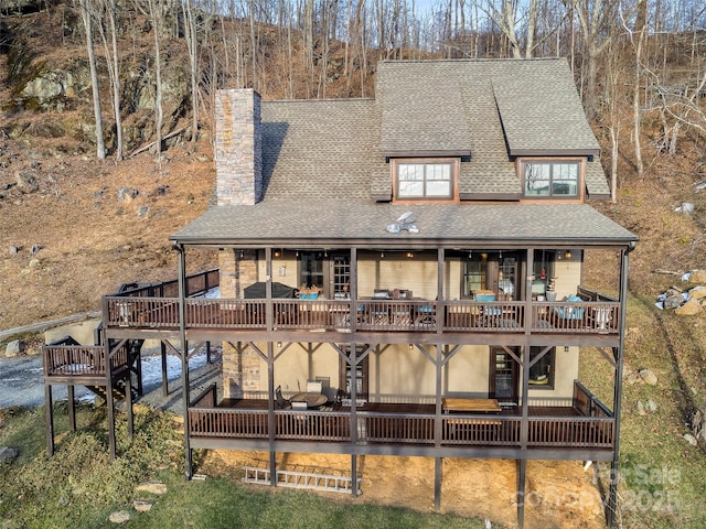 rear view of property with a deck and a patio area