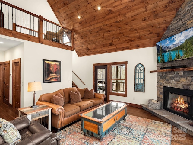 living room featuring wood ceiling, wood-type flooring, a stone fireplace, and high vaulted ceiling