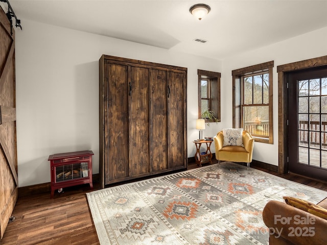 interior space with dark wood-type flooring and a barn door