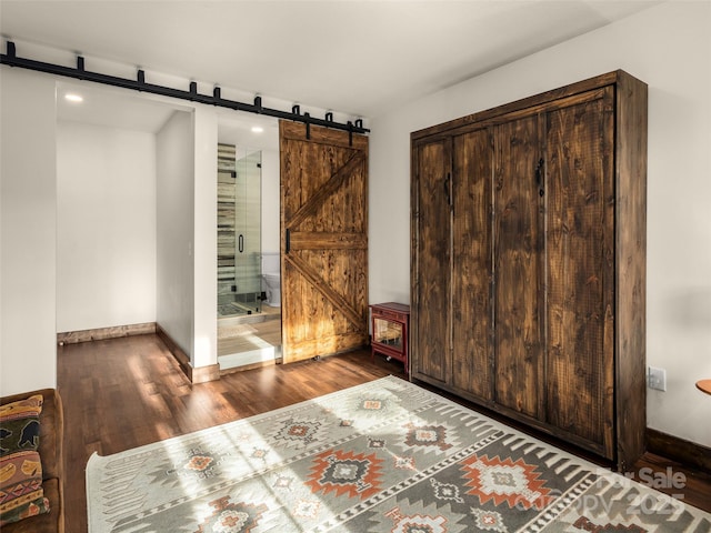 interior space with dark wood-type flooring and a barn door