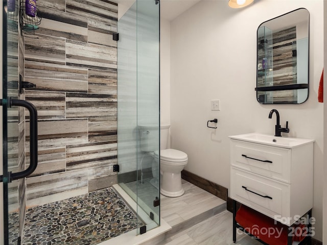 bathroom with vanity, toilet, and a shower with shower door