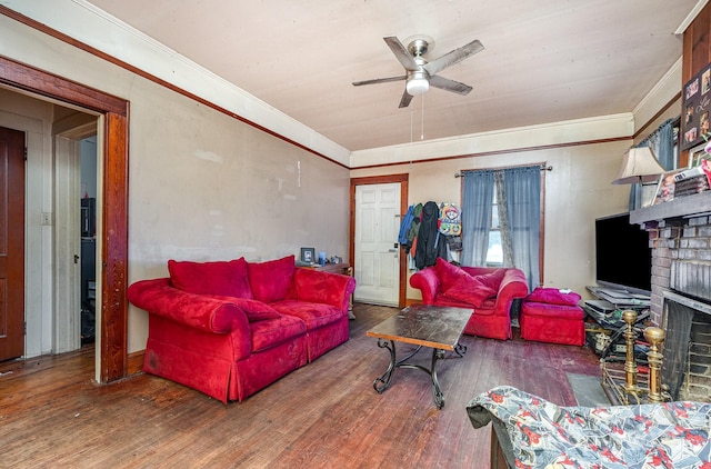 living room featuring ceiling fan, ornamental molding, dark hardwood / wood-style floors, and a fireplace