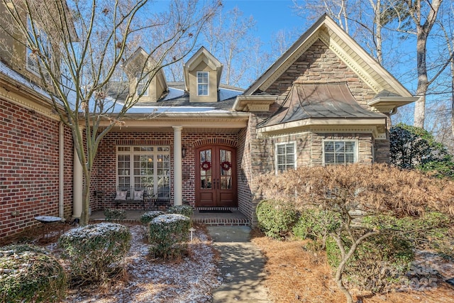 property entrance featuring covered porch and french doors