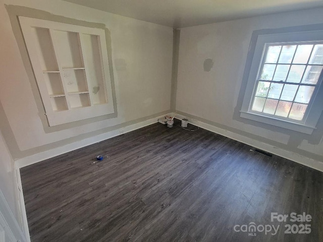 empty room with dark hardwood / wood-style flooring