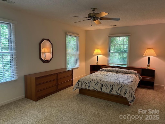 carpeted bedroom with a textured ceiling and ceiling fan