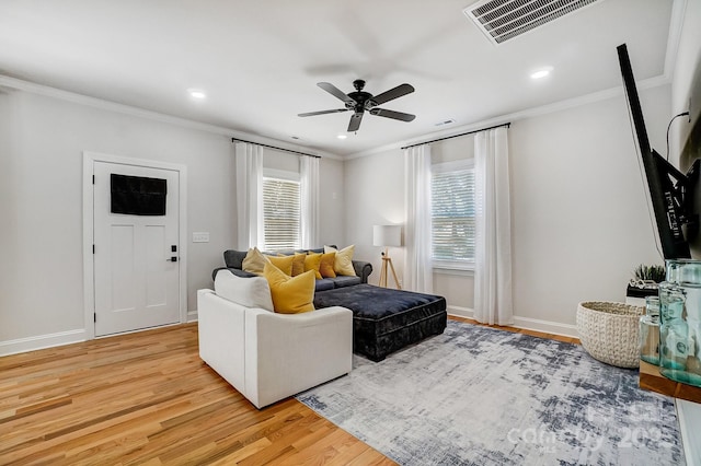 living room with hardwood / wood-style flooring, ornamental molding, and ceiling fan