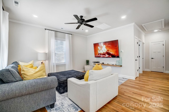 living room featuring wood-type flooring, ornamental molding, and ceiling fan