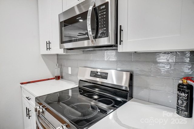 kitchen featuring white cabinetry, ceiling fan, stainless steel appliances, and backsplash