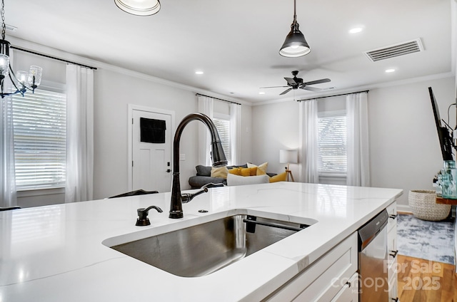 kitchen featuring sink, white cabinetry, crown molding, hanging light fixtures, and stainless steel dishwasher