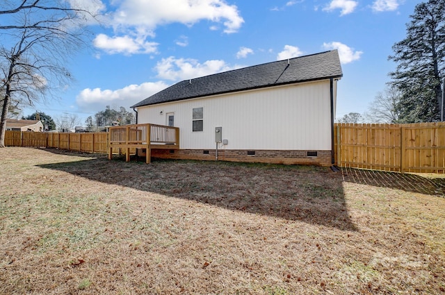 back of house with a wooden deck and a lawn