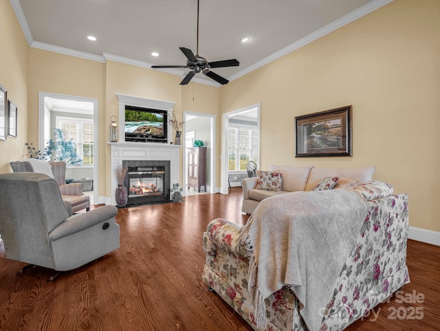 living room featuring hardwood / wood-style floors, crown molding, a wealth of natural light, and a fireplace