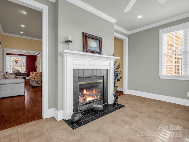 interior details featuring crown molding, ceiling fan with notable chandelier, and a fireplace