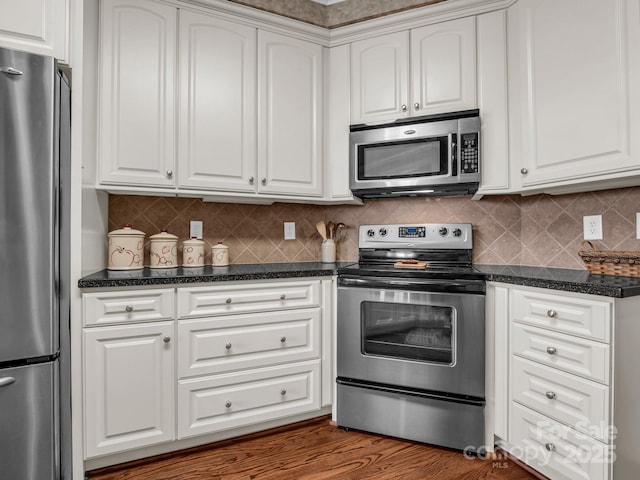 kitchen with tasteful backsplash, appliances with stainless steel finishes, dark hardwood / wood-style floors, and white cabinets