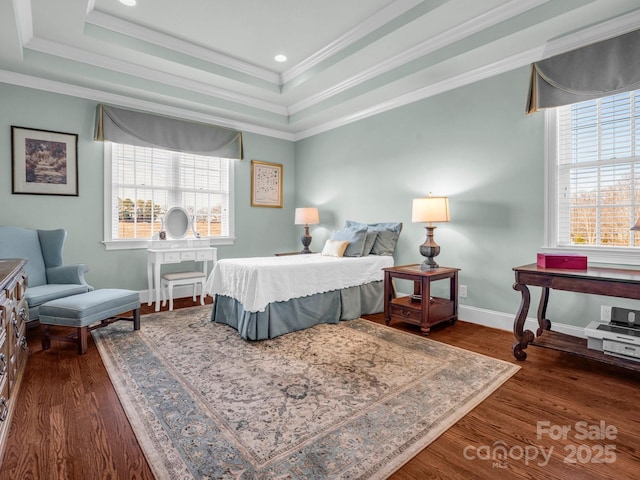 bedroom with ornamental molding, dark hardwood / wood-style flooring, and a tray ceiling