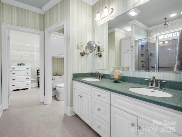 bathroom with vanity, crown molding, a shower with shower door, and toilet