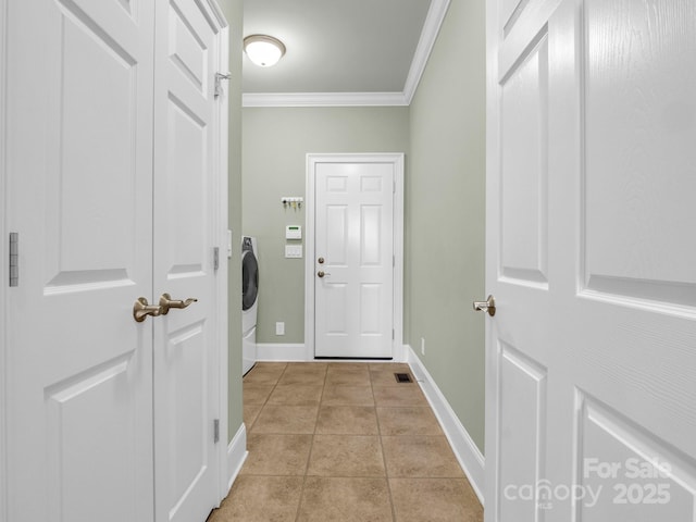 washroom featuring washer / clothes dryer, ornamental molding, and light tile patterned floors