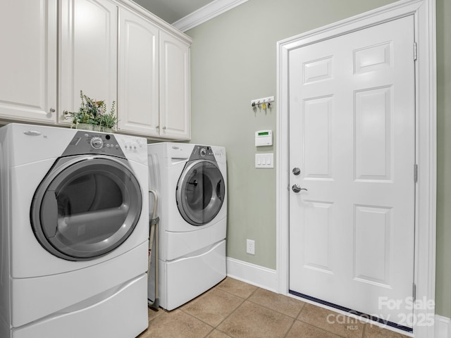 laundry area featuring cabinets, ornamental molding, washing machine and dryer, and light tile patterned floors