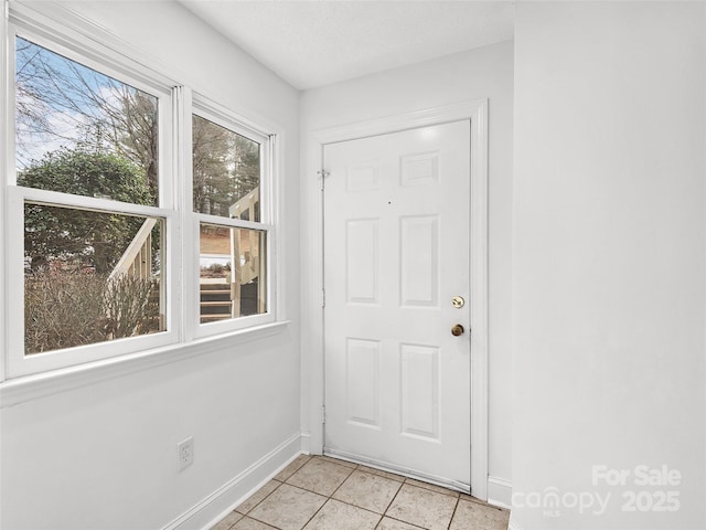 entryway with baseboards and light tile patterned floors